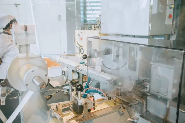 Ema servisu iha fatin manufatura semiconductor ho uniforme branku no maskeira, iha sentru teknolojia modernu