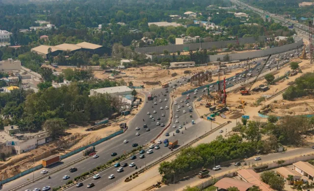 Imajen ida hatudu mákina pesadu sira servisu iha area construsaun estrada boot iha Uttan, India. Rai nakdoko no ema sira hare