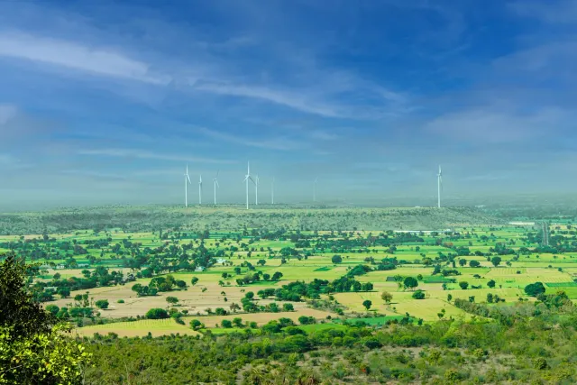 Imajen hatudu projetu renovável iha India ho mudansa klima iha kotuk, hanesan painel solar no turbina anin iha paisajen ne'eb