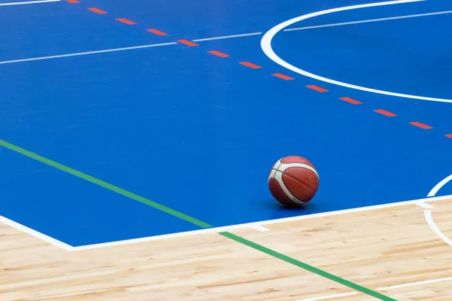 Imajen husi sala desportu ne'ebé sei konverte ba eskola medika, ho ekipamentu desportu no livru hamutuk, hatudu tensaun entre