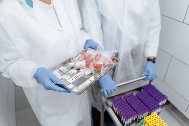 Imajen ida hatudu laboratóriu NIH ho sientista sira servisu ho material biolojiku perigozu, iha ekipamentu protesaun no sinai