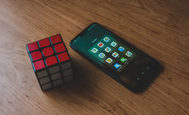 Ema ida uza smartphone atu resolve puzzle desportu NYT Connections Sports Edition iha meja, ho logu The New York Times iha te