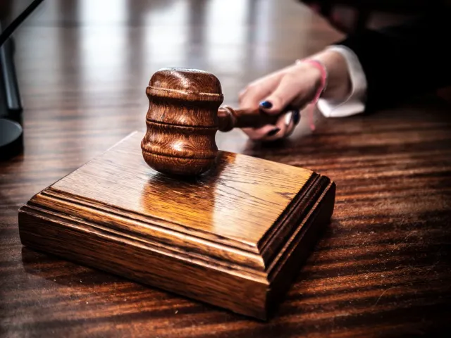 Imajen tribunal ho martelu no dokumentu legál, simboliza akasaun klase no risku legál ba negósiu