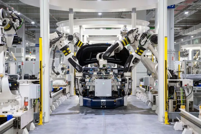 Fábrika karreta modernu ho linhas produsaun, ilustra impaktu tarifa karreta iha indústria automotiva global. Imajen ne'e hatu