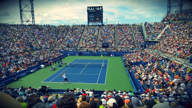 Imagem atleta tenis ho expresstaun triste iha estadiu, hatudu presaun pessoál no emosaun durante kompisaun
