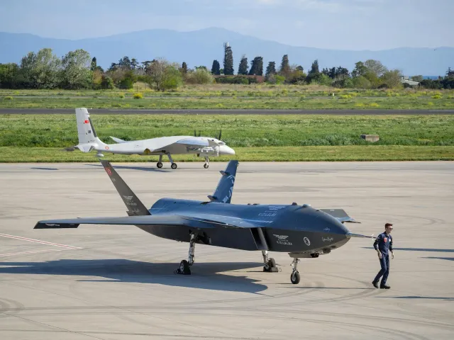 Imajen ida ne'ebé hatudu drone no AI iha kampu guerra, ho soldadu sira digital, atu ilustra oinsá AI no teknolojia drone muda