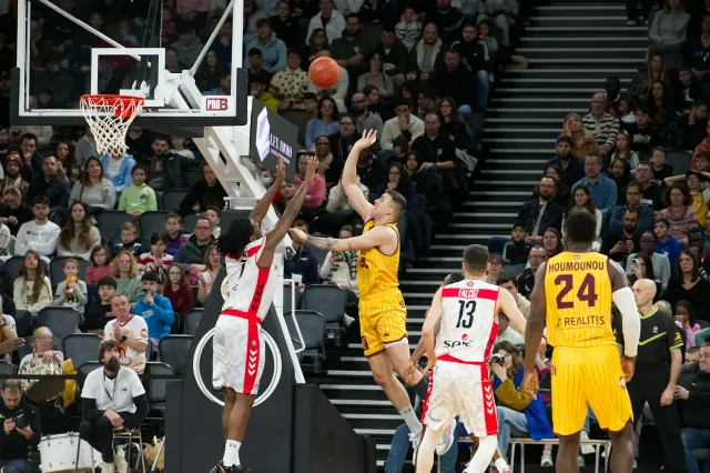 Imajen husi jogadór NBA nain rua halai iha kampu ho audiénsia barak iha sorin, hatudu tensaun no kompetisaun iha jogu boot NB