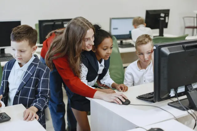 Estudante sira uza komputador iha klase, ho AI hanesan assistente iha ekrã, reprezenta aprendizajen ho teknolojia modernu
