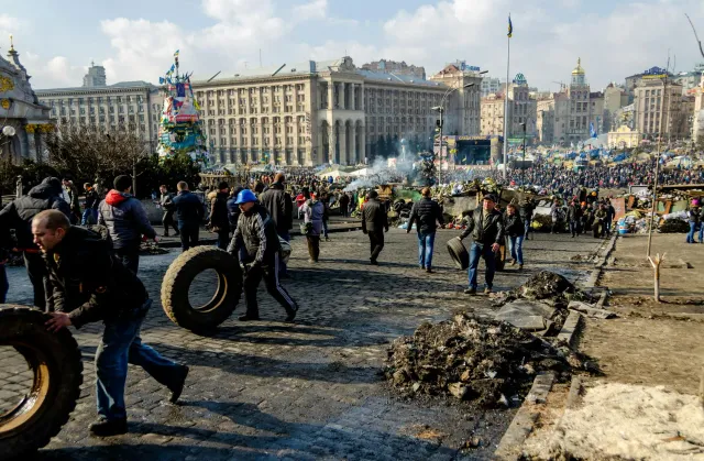 Imajen ida ne'ebé hatudu mapa mundu ho seta kór mean no azul, simboliza tensaun global entre nasaun sira, ho figura lider sir