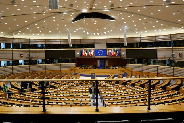 Imajen ida hatudu enkontru kona-ba regulamentu inteligénsia artifisiál iha Uniaun Europeia, ho banner sira ne'ebé hakerek 'AI