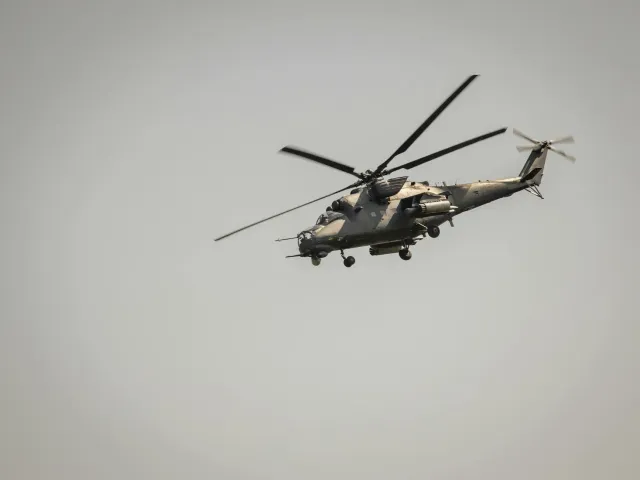 Imajen ida hatudu helikóteru militár Seahawk iha pista aviaun, ho soldadu estadu sira iha fundu, hanesan ilustrasaun ba artig