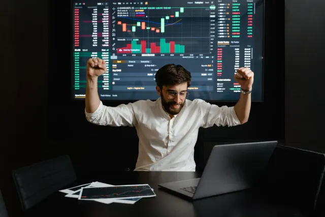 Imajen ilustrasaun kona-ba Elon Musk ho grafu merkadu saan no simbolu forex iha fundu, hatudu ligasaun entre predisaun boot n