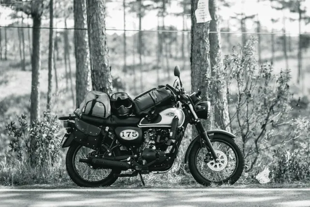 Imajen hatudu motór Kawasaki W175 kór metan ho detalhe ne'ebé klaru, iha fundu fábrika modernu — simboliza oinsá produtu husi