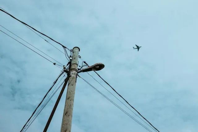 Aviaun elétriku Beta Technologies iha voo, ho ceu klaru no paisajem ne'ebé hatudu futuru aviasaun limpu no siénsia