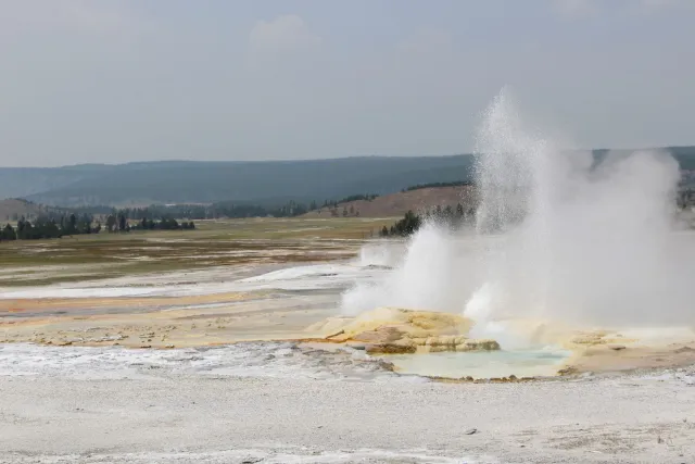Paisajen Parque Nasional Yellowstone ho krater vulkániku boot no fumaça husi atividade termál, ilustra forsa naturál ne'ebé i