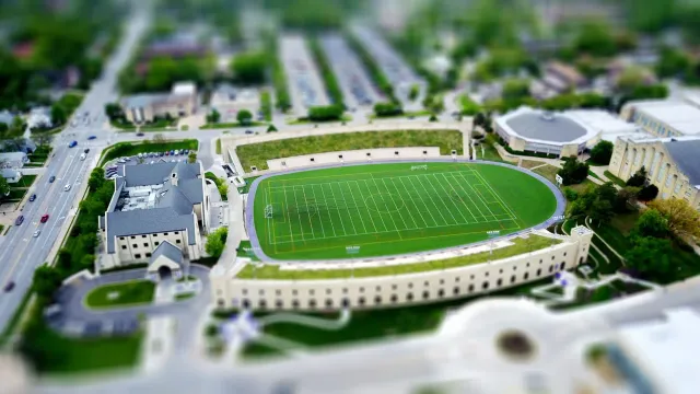 Imajen husi kampus Ursuline College ho kampu futebol iha kotuk, simboliza luta lejál iha deportu