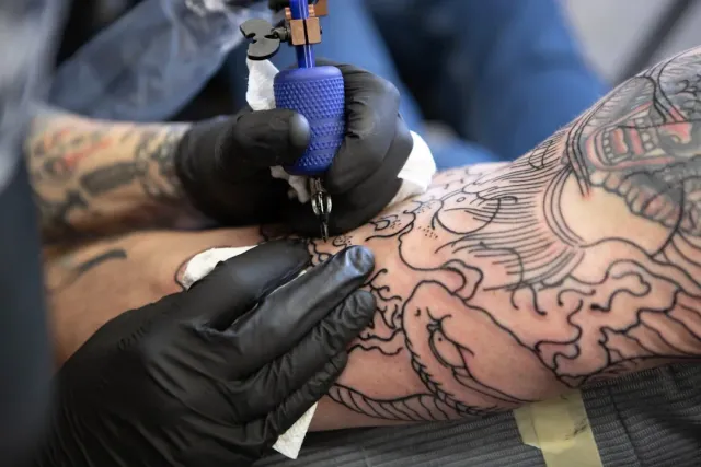 Ilustrasaun kona-ba oinsá sistema imunidade nia sélula sira — hanesan makrofagu — tenta atu limpa tinta tatuajen ne'ebé tama 