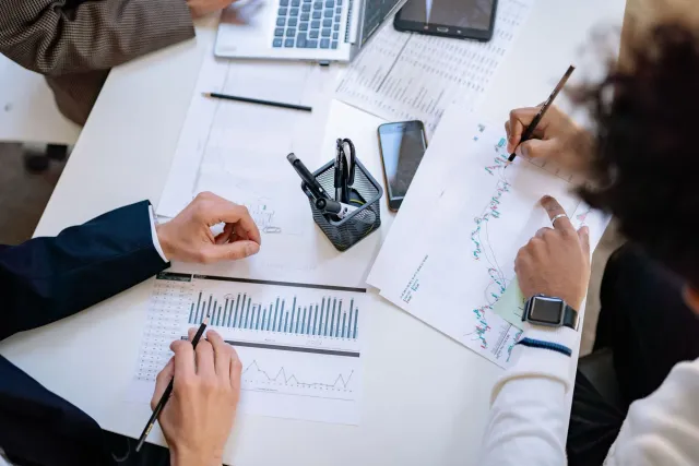 Imajin ekonomista ona iha desku, ona komputador no dokumentu, halo planu finansal iha escritório.