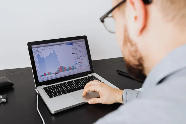 Ema negósiu ida tuur iha meza no analiza planu cloud computing iha komputador, ho ikon gráfiku no sínífiku AI