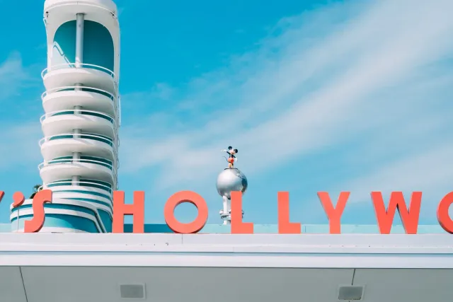 Bob Iger, xefe Disney, halibur hela iha entrevista, ho logotipu Disney iha kotuk, hanesan simbolu husi ambisaun boot maibe la