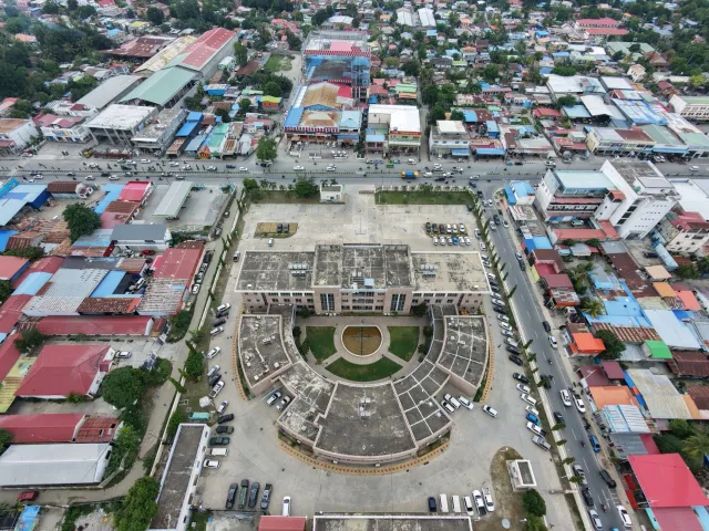 Edifísiu governu Timor-Leste ho bandeira nasionál no documentu lei komunikasaun iha meja, ilustrasaun kona-ba mudansa regulam