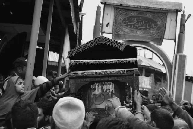 Imajen hatudu ema barak hakbesik iha Grand Mosalla iha Tehran durante preparasaun funerál ba Ayatollah Khamenei, ho bandera p