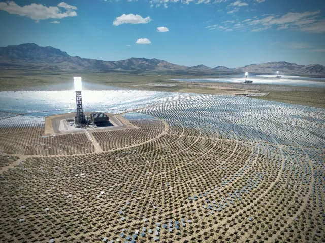 Imajen ida hatudu sientista sira ko'alia kona-ba transisaun enerjia iha workshop, ho mapa enerjia renovável iha latar, no ekr