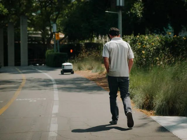 Drone médiku iha lalehan ho sidade iha kotuk, no ema ida la'o paseiu iha parke, simboliza kombinasaun entre hábits simples no