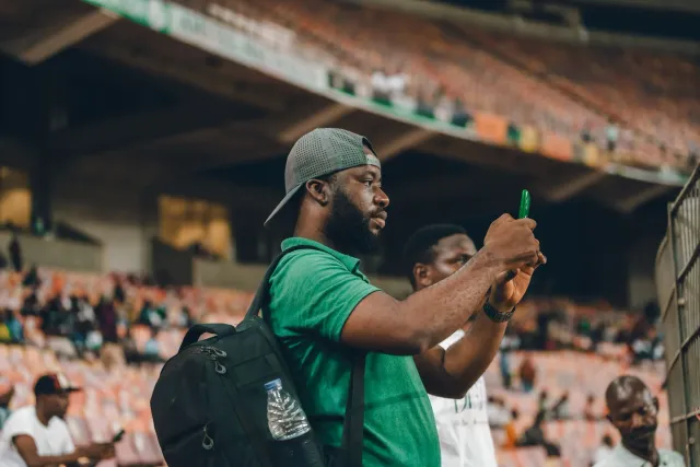 Ema ida uza smartphone atu buka informasaun desportu iha Facebook, ho tela hatudu AI mode no puzzle NYT Connections Sports Ed